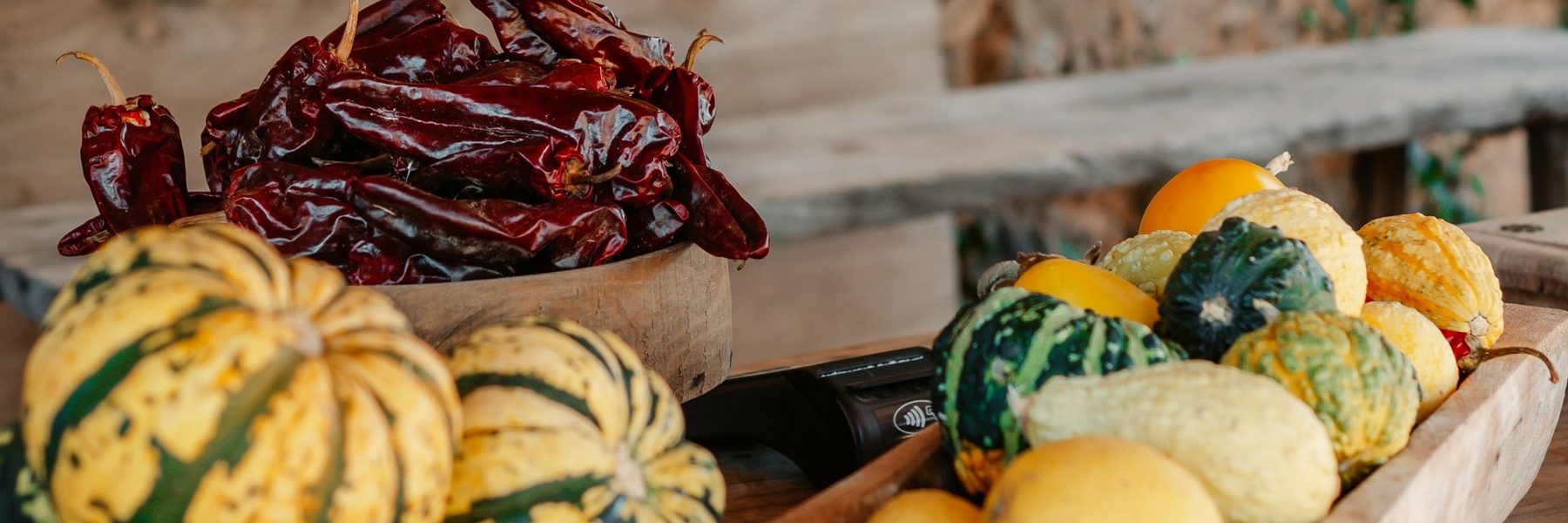 Dried chillies and pumpkins on a wooden market table